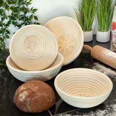 three bowls and two bread rolls on a table