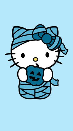 hello kitty holding a jack - o'- lantern in her arms and wearing a blue scarf