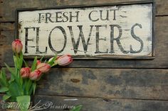 a sign that says fresh cut flowers and some tulips in front of it