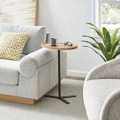 a living room with a couch, chair and coffee table in front of a window