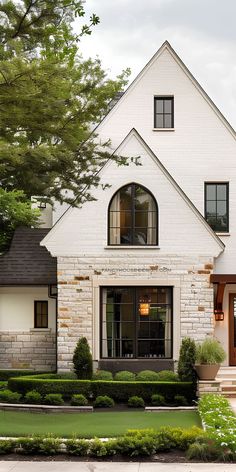 a white brick house with black trim and windows