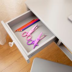 a drawer with scissors and pencils in it