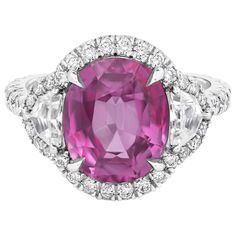 A charming three-stone engagement ring style, showcasing an AGL certified oval cut pink sapphire weighing 5.73 carats, set on a four claw prong setting. Flanked by epaulette diamonds weighing 0.56 carat total. Surrounded by a halo of round brilliant cut diamonds that continue on to the shank in a half-way design. Accent diamonds weigh 0.84 carat total. Made with 18K white gold. Size 6.5 US, resizable upon request. Roman Malakov is a custom house, specializing in creating anything you can imagine Art Jewelry Ring, Pink Sapphire Ring Engagement, Contemporary Engagement Rings, Three Stone Diamond, Three Stone Engagement, Beautiful Engagement Rings, Three Stone Engagement Rings, Engagement Ring Styles, Halo Diamond Engagement Ring