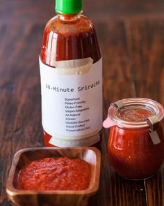 there is a jar of sauce next to a container of sauce on the table with another bottle in it