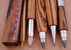 four wooden pencils are lined up next to each other