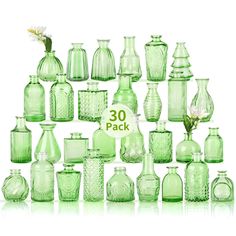 a collection of green glass vases sitting next to each other