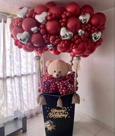 a teddy bear in a basket filled with balloons