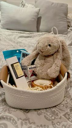 a stuffed animal sitting in a basket on top of a bed