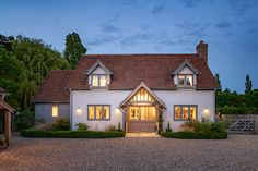 a large white house with lots of windows and lights on it's front door