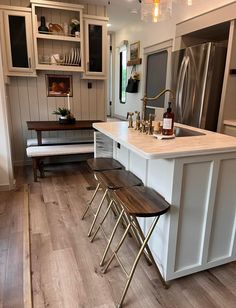 a kitchen with white cabinets and wooden floors