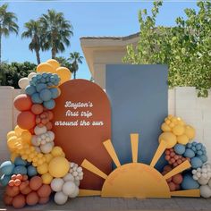 balloons are arranged around the sun in front of a memorial sign that reads everyone's first day around the sun