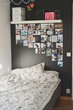 a bed sitting under a wall covered in pictures