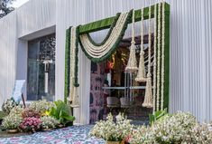 an entrance to a building decorated with flowers and greenery for a wedding ceremony or reception