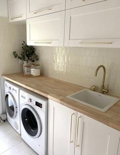 a washer and dryer sitting in a kitchen next to a counter with a potted plant on it