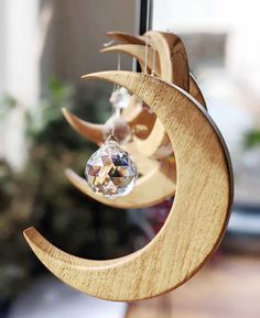 a wooden moon and crescent mobile hanging from a window