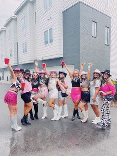 a group of young women standing next to each other on top of a parking lot