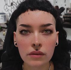 a woman with piercings on her nose looking at the camera