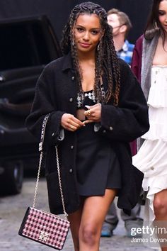 a woman walking down the street carrying a purse