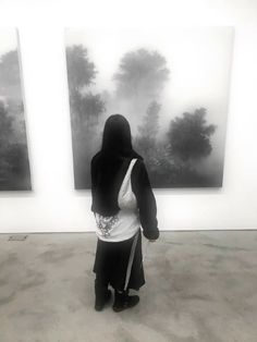 a woman standing in front of two paintings