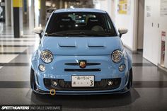 a small blue car parked in a building