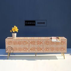 an orange and white dresser with flowers on it in front of a blue wall that says canvas home