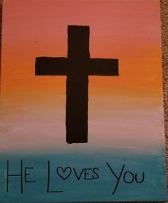 a painted cross with the words he loves you on it