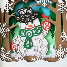 a paper cut snowman with a hat and scarf