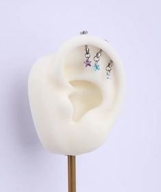 the ear is made out of plastic and has two charms attached to it