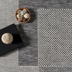 a black and white checkered table cloth next to a wooden bowl with rocks in it