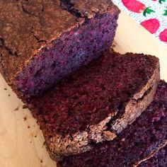 a loaf of chocolate cake sitting on top of a wooden cutting board