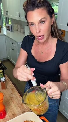 a woman making food in the kitchen with an electric blender on her counter top