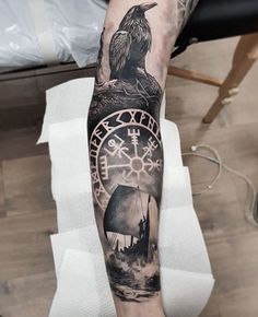 a person with a tattoo on their arm holding a clock and an eagle sitting on top of it