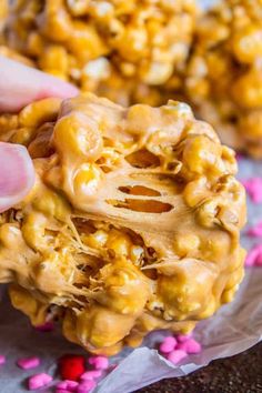 a hand holding up a peanut butter popcorn ball