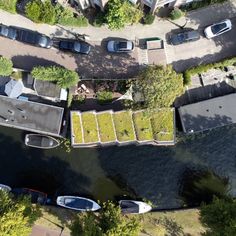 an aerial view of houses and boats on the water in a residential area with green roofs