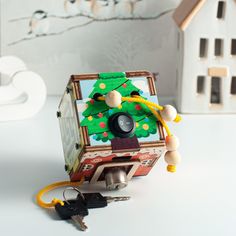 a wooden box with a christmas tree on it and some keys in front of it