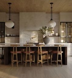 a large kitchen with an island and bar stools in front of the countertop