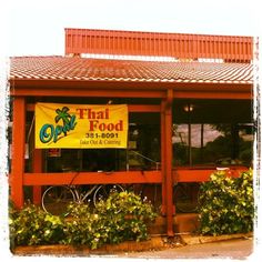 a thai food restaurant with bikes parked outside