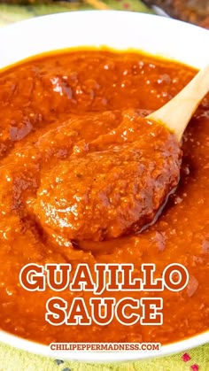 a close up of a bowl of sauce with a wooden spoon in it and the words guanillo sauce