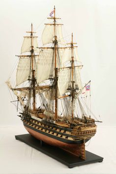 a model sailing ship on a white surface