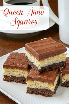 four pieces of cake sitting on top of a white plate next to a cup of coffee