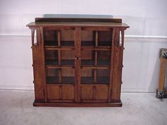 a wooden cabinet with glass doors on top