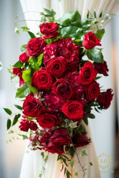 a bouquet of red roses and green leaves