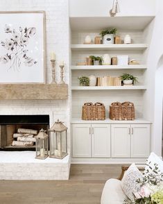 a living room filled with furniture and a fire place in front of a white brick wall