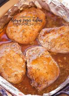 four pork chops in a pan with sauce