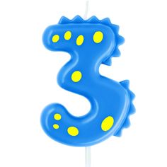 a blue candle with yellow dots in the shape of a seahorse on a stick