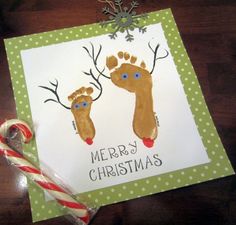 a christmas card with two handprinted feet and candy canes on the table