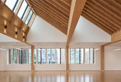 an empty room with high ceilings and wooden beams on the ceiling is lit by bright windows