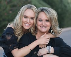 two women are hugging each other outside