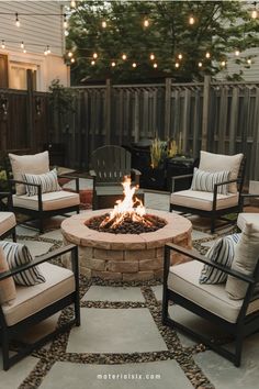 Cozy outdoor patio with a fire pit surrounded by chairs and string lights overhead.