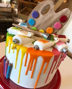 a cake decorated with paint and art supplies